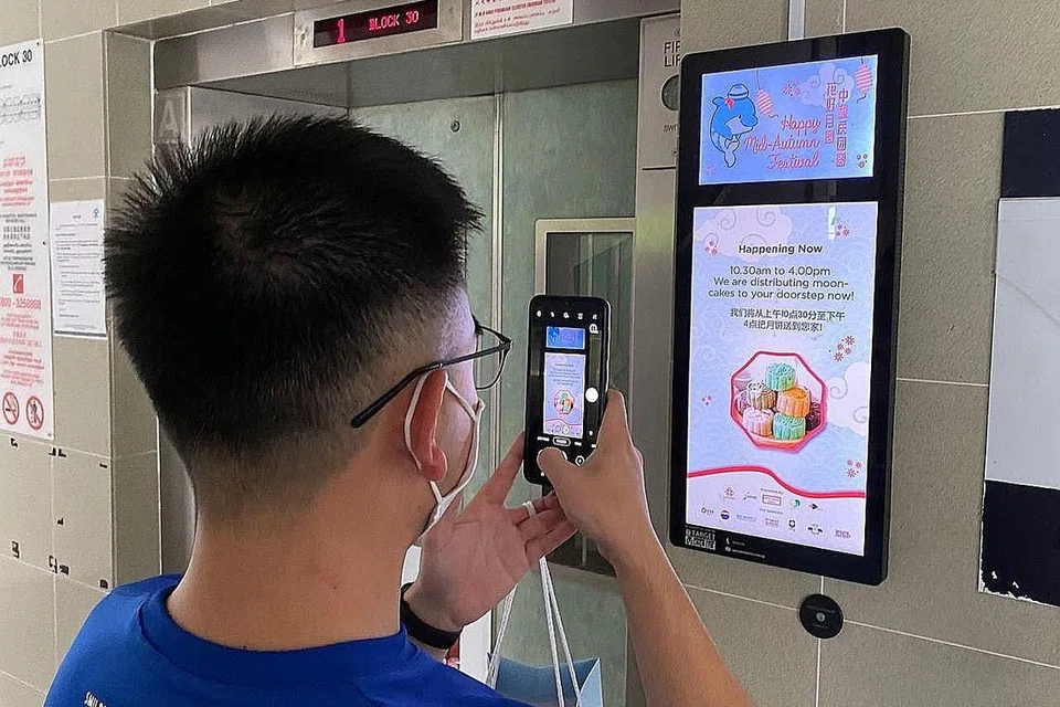 PANEL PAPARAN DIGITAL: Relawan belia dari Rangkaian Belia Kampong Kembangan 'meneroka' kandungan dalam DPP. Menerusi proses pendigitalan ini, ia membuat pengagihan dijalankan lancar dan beliau mendapat peluang untuk memahami penduduk dengan lebih baik. - Foto PERTUBUHAN AKAR UMBI GRC MARINE PARADE (GRO)