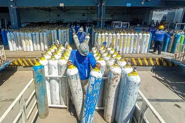 BUAT PERSIAPAN EDARKAN OKSIGEN: Pekerja di syarikat pembekal oksigen menyediakan silinder untuk diedarkan di Semarang, Jawa Tengah semalam. Indonesia juga telah memesan 10,000 unit pemekat oksigen dari Singapura. - Foto AFP
