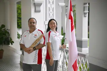 Perenang Gan Ching Hwee (kanan) dan atlet boling padang para Mawjit Singh Gurmet Singh (kiri) merupakan pembawa bendera bagi  kontinjen Singapura di Majlis Pembukaan Sukan Komanwel Glasgow. Temasya tersebut akan berlangsung pada 23 Julai hingga 2 Ogos.