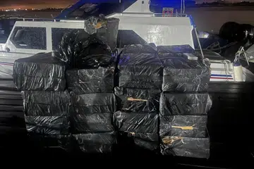 Kotak rokok haram disusun di hadapan sebuah bot rondaan kastam di lokasi yang tidak didedahkan di Batam, Kepulauan Riau, dalam gambar tidak bertarikh yang dikeluarkan Kastam dan Cukai Eksais Batam. Sebanyak 11 daripada 54 kes rampasan yang direkodkan pada Mei lalu membabitkan rokok seludup.