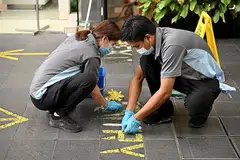 LANGKAH DILONGGAR: Pekerja membuka pelekat yang ditampal sebagai sebahagian daripada langkah pengurusan selamat di pintu masuk sebuah bangunan. - Foto BH oleh LIM YAOHUI