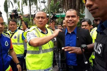 DIKENAKAN DENDA: Pengerusi Gabungan NGO Malaysia, Datuk Seri Jamal Md. Yunos diiringi anggota polis selepas dia didakwa Mahkamah Majistret di sini semalam kerana melakukan mudarat awam dengan memecahkan botol arak menggunakan penukul besi di hadapan pintu pagar Bangunan Sultan Salahuddin Abdul Aziz Shah di sini tahun lalu. - Foto UTUSAN ONLINE