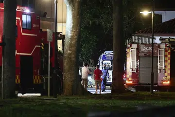 OPERASI SELAMATKAN MANGSA: Pegawai SCDF dikerahkan untuk memotong pokok besar yang tumbang dekat Kelab Masyarakat Ulu Pandan yang memerangkap dua orang manakala seorang lagi cedera dalam kejadian kelmarin. - Foto BH oleh KELVIN CHNG