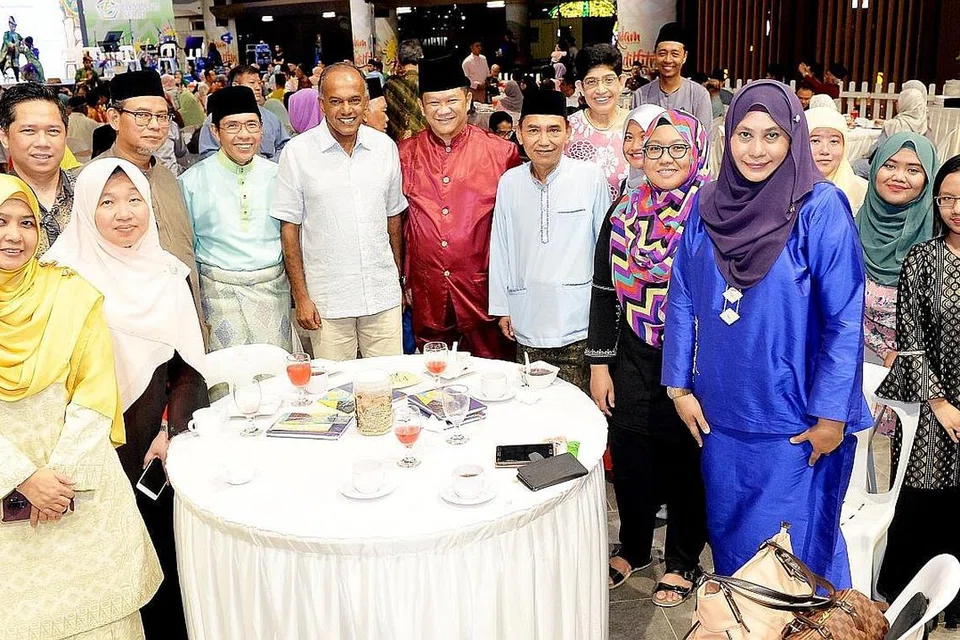 SAMBUT SAMA: Wartawan dan kakitangan Berita Harian sempat bergambar bersama Encik K. Shanmugam (enam dari kiri), Dr Mohamad Maliki Osman (lima dari kiri), Profesor Madya Dr Fatimah Lateef (empat dari kanan) serta Encik Saat A Rahman (lima dari kanan) di acara Syawal Muhibah di Wisma Geylang Serai malam kelmarin. - Foto BM oleh KHALID BABA