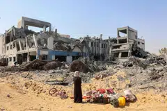 Seorang wanita menatap sayu runtuhan kompleks bangunan Agensi Bantuan dan Kerja Menyelamat Pertubuhan Bangsa-Bangsa Bersatu bagi Pelarian Palestin (UNRWA) selepas pengunduran tentera Israel pada 12 Julai.