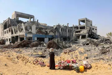 Seorang wanita menatap sayu runtuhan kompleks bangunan Agensi Bantuan dan Kerja Menyelamat Pertubuhan Bangsa-Bangsa Bersatu bagi Pelarian Palestin (UNRWA) selepas pengunduran tentera Israel pada 12 Julai.