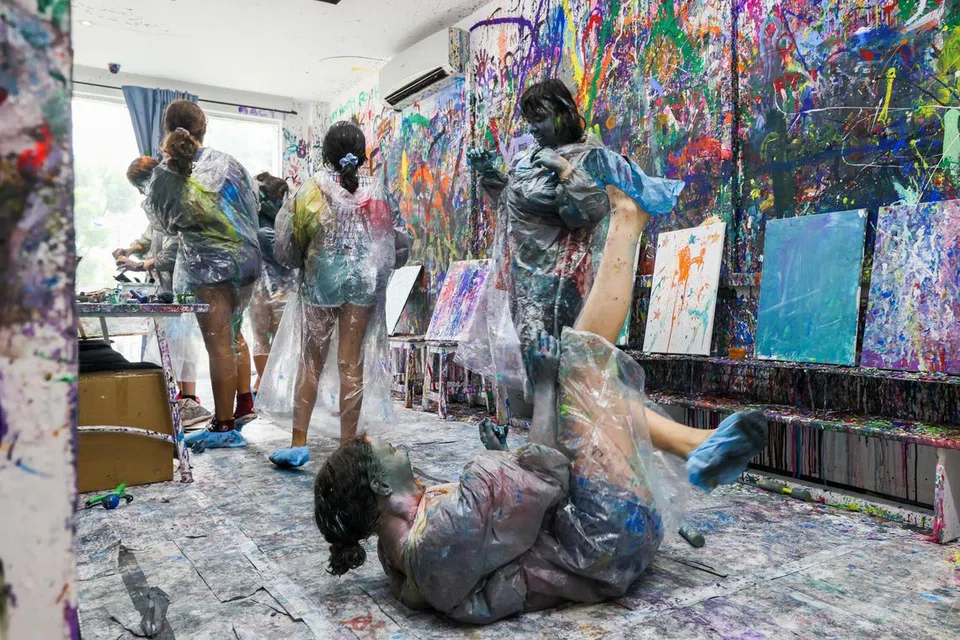 TUNJUKKAN KREATIVITI: Anggota keluarga boleh menikmati masa bersama di ‘arena simbah cat’ di Splat Paint House.