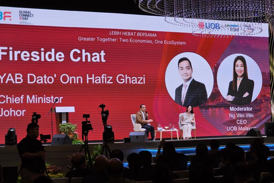 Menteri Besar Johor, Datuk Onn Hafiz Ghazi (kiri) berkongsi perkembangan projek Zon Ekonomi Khas Johor-Singapura (JS-SEZ) dalam sesi perbincangan yang dikendalikan oleh Ketua Pegawai Eksekutif (CEO) UOB Malaysia, Cik Ng Wei Wei.