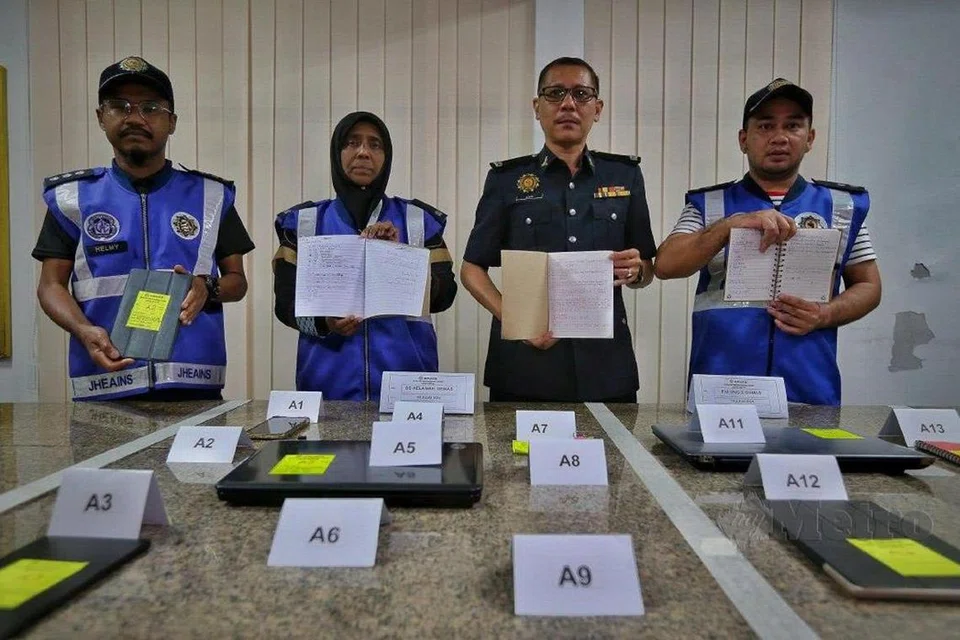 Ketua Unit Operasi Bahagian Penguatkuasaan Jabatan Hal Ehwal Agama Islam Negeri Sembilan (JHEAINS), Encik Ahmad Zaki Hamzah (tiga dari kiri), menunjukkan pelbagai barang yang disyaki mempunyai kaitan dengan ajaran sesat, ‘Millah Abraham’, yang dirampas daripada tiga beranak yang ditahan.