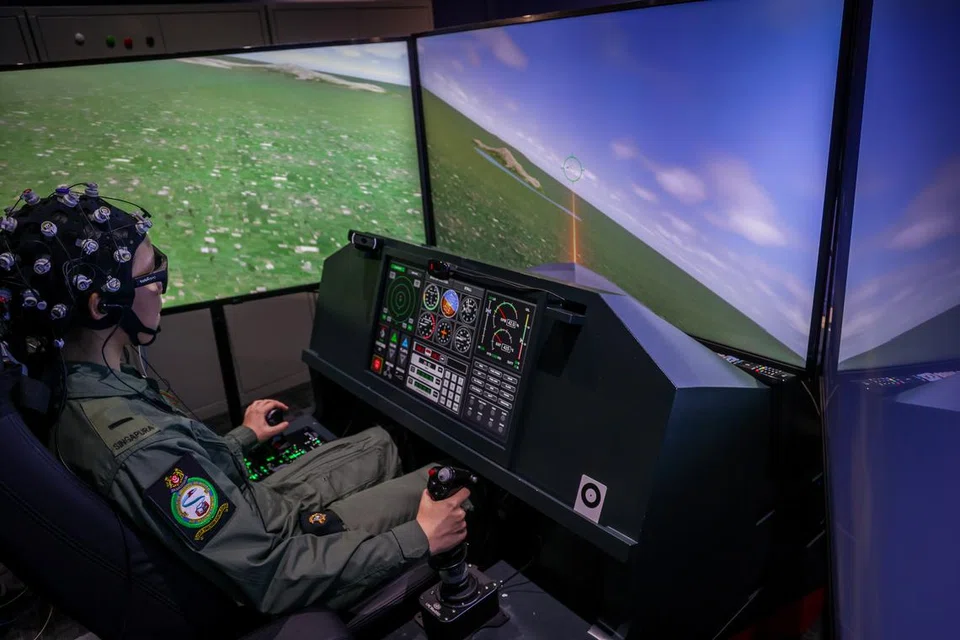 TEKNOLOGI SIMULASI: Seorang  juruterbang pelatih RSAF kelihatan sedang menyerang dan menembak kapal terbang musuh dalam skrin menerusi sistem simulasi Projek SOAR yang berbentuk persis kokpit jet pejuang.