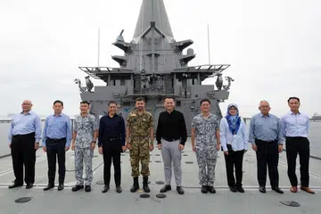 TINJAU OPERASI DI PANGKALAN: Putera Al-Muhtadee Billah (lima dari kiri), Dr Maliki (empat dari kiri) dan Encik Zaqy (lima dari kanan) bergambar bersama semasa lawatan Putera Mahkota Brunei itu ke RSS Singapura - Pangkalan Tentera Laut Changi semalam. - Foto MINDEF