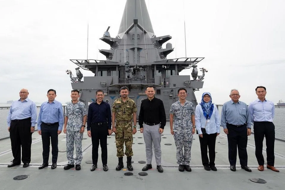 TINJAU OPERASI DI PANGKALAN: Putera Al-Muhtadee Billah (lima dari kiri), Dr Maliki (empat dari kiri) dan Encik Zaqy (lima dari kanan) bergambar bersama semasa lawatan Putera Mahkota Brunei itu ke RSS Singapura - Pangkalan Tentera Laut Changi semalam. - Foto MINDEF