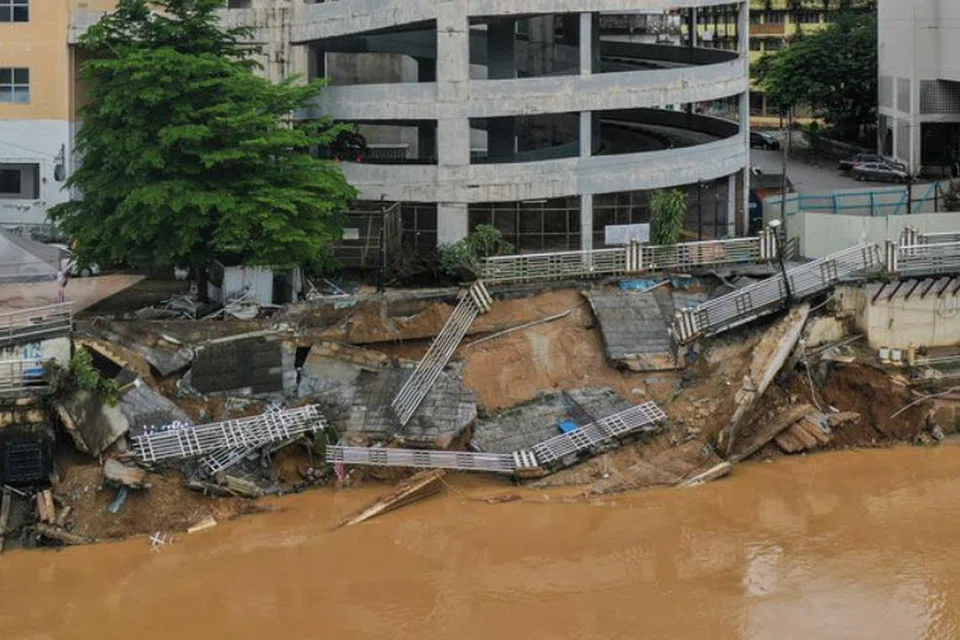 Kesan pascabanjir di Kota Bharu, Kelantan, di mana kawasan bangunan berhampiran sebuah pangsapuri dan pusat penginapan di tebing Sungai Kelantan mengalami runtuhan.