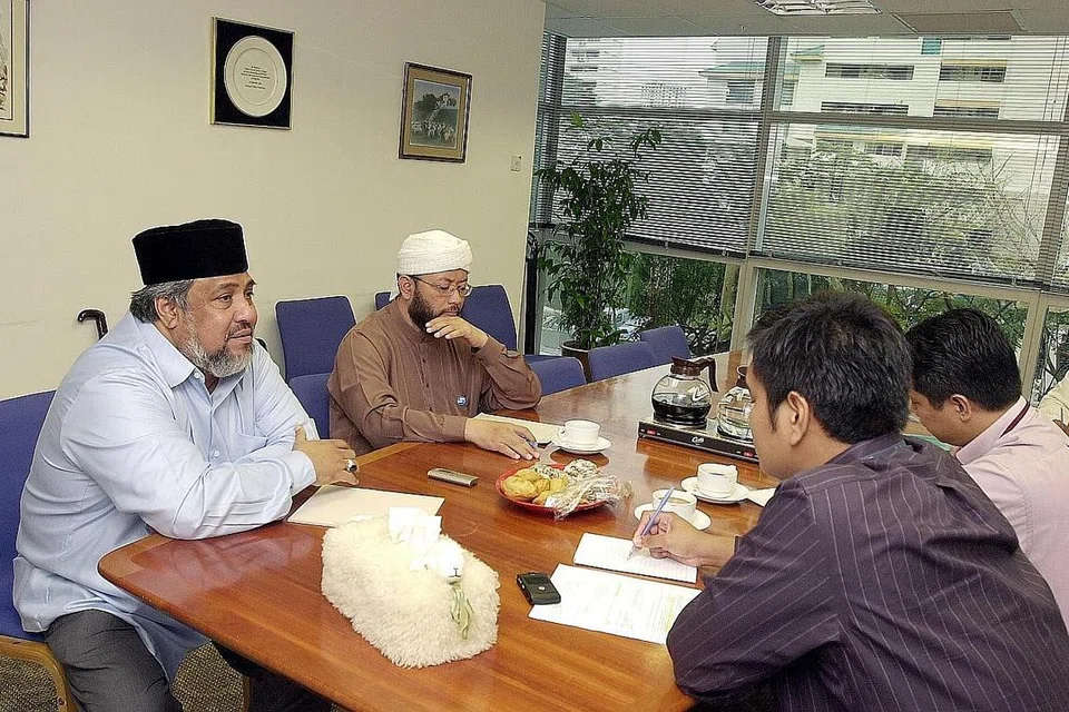 ORAK LANGKAH: Ustaz Ali Haji Mohamed (kiri) dan Ustaz Mohamad Hasbi Hassan (dua dari kiri) semasa diwawancara di pejabat Berita Harian sewaktu menerangkan pembentukan RRG yang dilancarkan pada 23 April 2003. Menyusuli penangkapan kumpulan pertama anggota JI, pihak keselamatan negara mendapatkan para asatizah pemimpin masyarakat Islam untuk membantu dalam kaunseling para tahanan, yang membawa kepada penubuhan RRG. - Foto fail