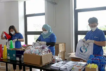 PEK PEMBELAJARAN: Relawan kakitangan SP, yang juga dikenali sebagai SP Heart Workers, sedang menyiapkan barang dalam pek pembelajaran bagi kanak-kanak di bawah program SP Kids at Heart. Barang ini termasuk mainan, buku dan bahan pendidikan. - Foto SP GROUP