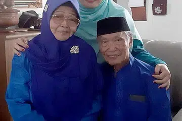 DEMI ORANG TUA: Mahyonis (tengah) rela terpisah daripada suami dan anak-anak demi bersama ibunya, Ponisah Bachik dan bapanya, Mahfudz Abdul Majid, di rumah mereka di Johor Bahru. - Foto ihsan MAHYONIS MAHFUDZ