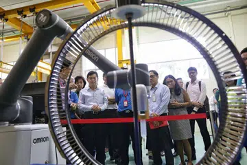 GUNA TEKNOLOGI BARU: Encik Heng (kiri) menyaksikan robot yang digunakan untuk kerja penyenggaraan di ST Engineering Aerospace semalam. Menurut Encik Heng, syarikat itu harus dicontohi kerana menggunakan teknologi baru dan bekerjasama dengan NTUC untuk menaik taraf pekerjanya. . - Foto BH oleh KEVIN LIM