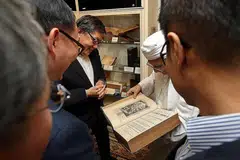 TAK KENAL MAKA TAK CINTA: Habib Hassan (berserban) menunjukkan sebuah kitab lama yang dijadikan bahan koleksi bersejarah di Masjid Ba'alwie kepada Paderi Yang (Tengah). - Foto BH oleh SEAH KWANG PENG