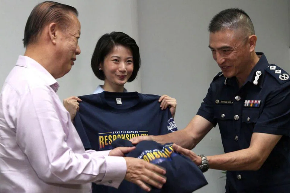 TANGGUNGJAWAB SEMUA: Cik Sun (tengah) dipersembahkan kemeja-T yang dicetak Take Road to Responsibility, tema edisi kedua inisiatif, Use Your RoadSense, oleh SAC Lim (kanan) dan Pengerusi Majlis Keselamatan Jalan Raya Singapura Encik Bernard Tay. - Foto BH oleh ZAIHAN YUSOF