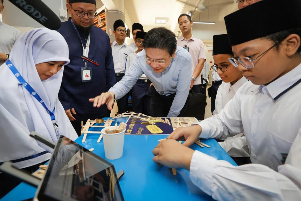 Perdana Menteri Encik Lawrence Wong (tengah) bertemu dan berinteraksi dengan pelajar Madrasah Aljunied Al-Islamiah.