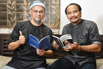 ENGGAN KEINDAHAN BAHASA PUDAR: Khair Yasin (kiri) dan Azman Shariff, yang bekerjasama bagi Bengkel Mutiara Kata untuk membimbing peserta dalam penulisan lirik, puisi dan madah Sabtu ini, mahu melihat generasi muda terus minat menulis dalam bahasa Melayu dengan ciri-cirinya yang indah. - Foto BH oleh DESMOND WEE