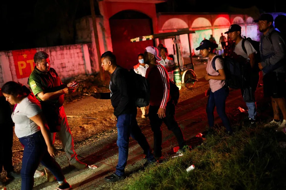Seorang ejen Institut Migrasi Nasional (INM) memeriksa dokumen para migran sebelum mereka menaiki kenderaan Institut Migrasi Nasional (INM) untuk dibawa dan memproses permit perjalanan melalui Mexico dalam usaha untuk menuju ke sempadan Amerika Syarikat, di Mapastepec, wilayah Chiapas, Mexico pada 18 Januari.