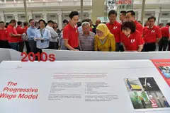 PENGAJARAN SEJARAH: Puan Halimah (berbaju kuning) meneliti Pameran 'ReUnion' oleh NTUC yang meraikan ulang tahun ke-50 Seminar Kesatuan Perdagangan mengenai Pemodenan Gerakan Buruh. Turut menemaninya ialah Presiden NTUC, Cik Mary Liew (kanan); Setiausaha Agung NTUC, Encik Ng Chee Meng (belakang Puan Halimah) dan para pemimpin gerakan buruh yang lain. - Foto BH oleh NG SOR LUAN