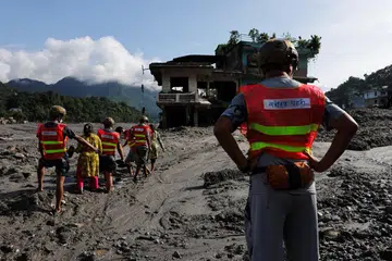Anggota penyelamat membantu beberapa wanita meredah jalan berlumpur susulan banjir kilat dan tanah runtuh di Trishuli, daerah Nuwakot, Nepal, pada 28 Ogos. Operasi mencari dan menyelamat terus dipergiat ketika ancaman banjir baharu membayangi kawasan lembah di sempadan Nepal-China, selepas bencana itu meragut ratusan nyawa dan menyebabkan ramai lagi masih hilang