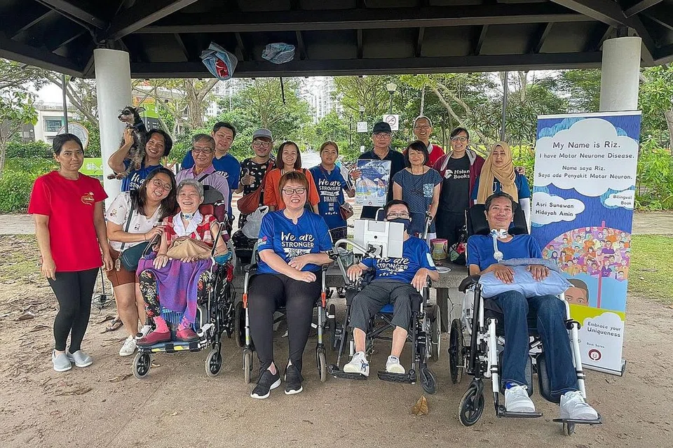 BERSAMA PESAKIT MND: Riz Sunawan bersama para pesakit dan penyokong Persatuan Penyakit Motor Neuron semasa sesi pengagihan bukunya Nama saya Riz. Saya ada Penyakit Motor Neuron di East Coast Park pada 28 Januari lalu. - Foto fail