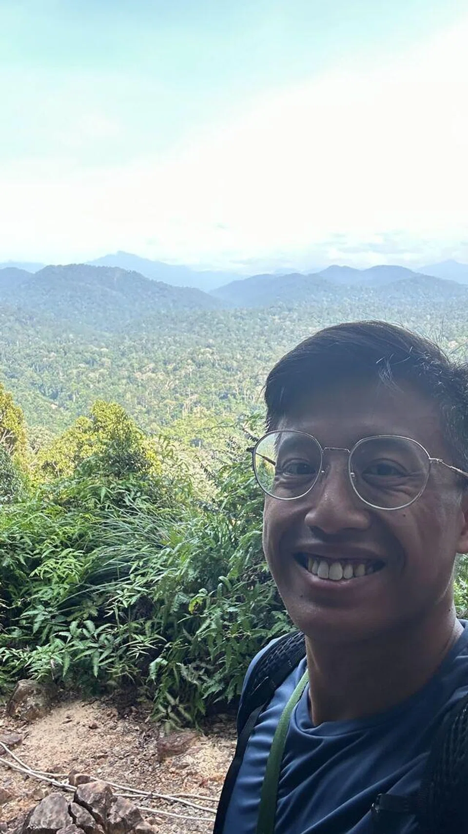 Penulis berlatarkbelakangkan pemandangan puncak bukit lain dari puncak Bukit Teresek yang terletak di Taman Negara.