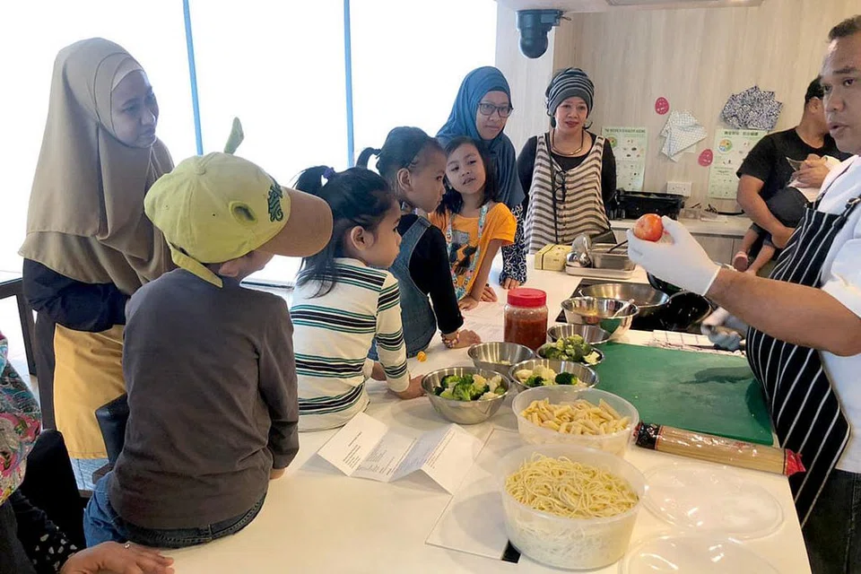 ERATKAN JALINAN: Kegiatan seperti kelas memasak untuk golongan ibu dan anak-anak yang dianjurkan di studio kulinari Kelab Masyarakat Nee Soon East ini merupakan antara usaha merapatkan hubungan kekeluargaan. - Foto M³@NEE SOON