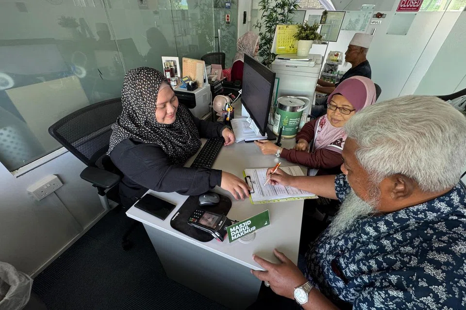 Pegawai Khidmat Jemaah, Cik Fazlyana Mohd Fadil (kiri), menerima sumbangan wakaf daripada penderma di pejabat sementara masjid yang terletak di Masjid Assyafaah.
