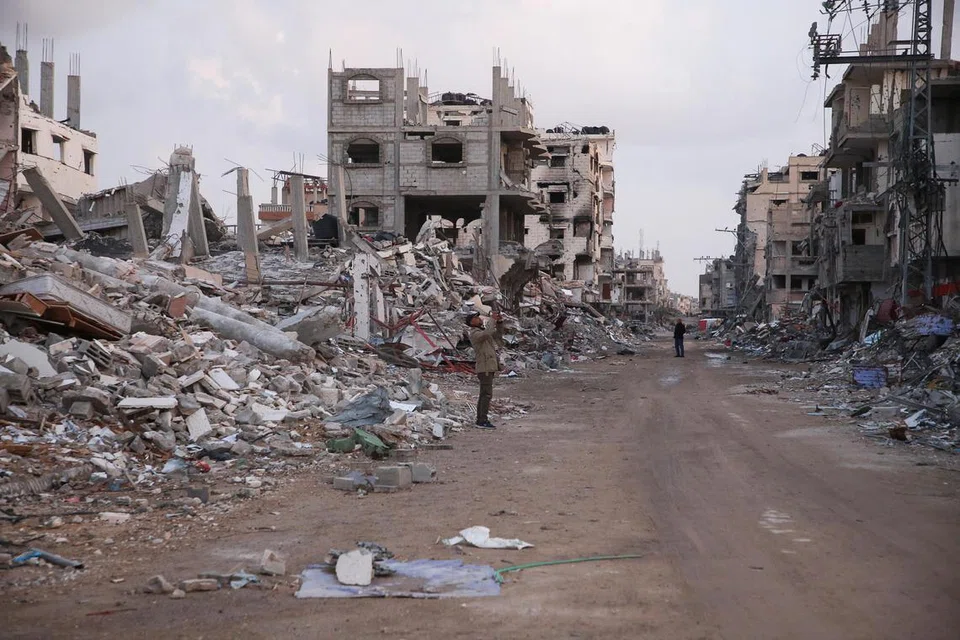 Seorang penduduk Gaza berdiri di sebelah runtuhan bangunan yang musnah akibat serangan Israel, di tengah-tengah gencatan senjata antara Israel dengan Hamas, di Rafah, selatan Jaluran Gaza, pada 5 Februari.