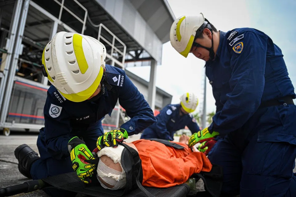 PAMER KEMAHIRAN: Anggota Pasukan Kadet Pertahanan Awam Kebangsaan (NCDCC) memberi pertolongan cemas kepada ‘mangsa’, memaparkan kebolehan mereka dalam tindak balas kecemasan pada pusingan awal Cabaran Anggota Bomba dan Paramedik Singapura-Global (SGFPC).