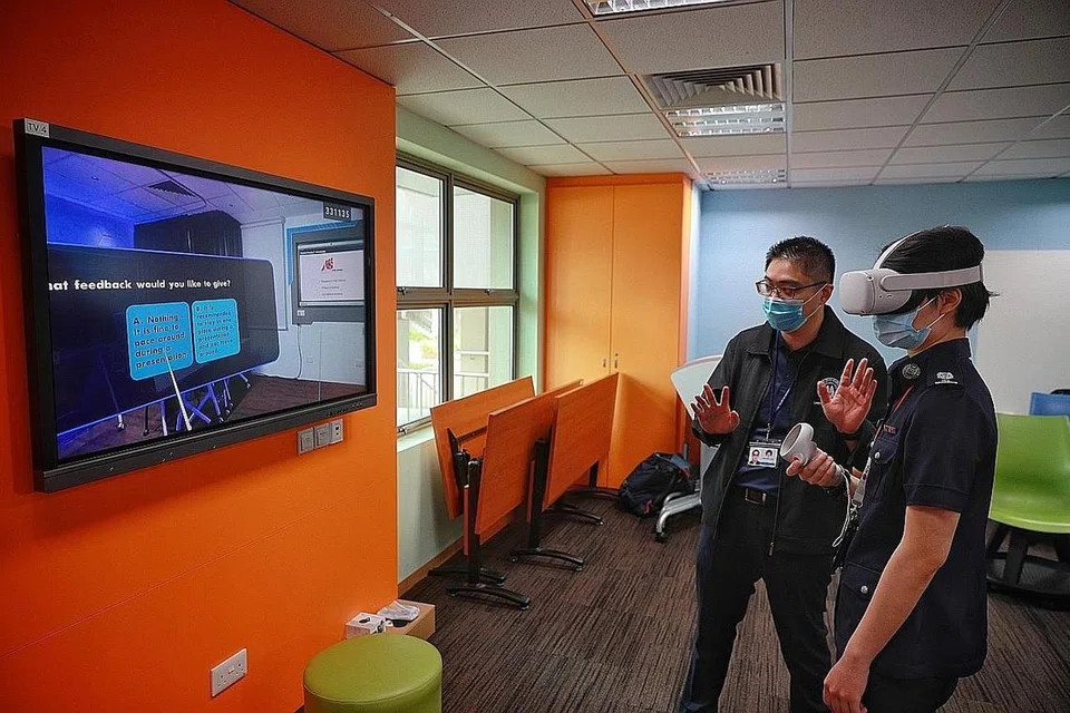 MANFAATKAN TEKNOLOGI REALITI MAYA: Jurulatih Besar, Komand Latihan Penguasa Imigresen dan Pusat Pemeriksaan (ICA), ASP Sophia Ng kelihatan sedang menjalani simulasi mengendali sebuah kelas Realiti Maya (VR) sambil menerima bimbingan oleh Eksekutif Kanan (Perancangan Kurikulum), Pusat bagi Sistem Pembelajaran Akademi Home Team, Encik Ian Koh. - Foto-foto BH oleh JASON QUAH