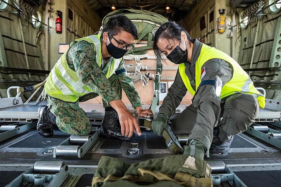 BEKERJASAMA RAPAT: Askar dari tentera laut dan tentera darat sedang melakukan pemeriksaan ke atas peralatan berat sebelum latihan bermula. - Foto MINDEF