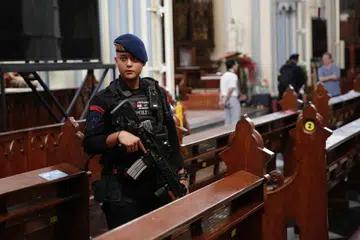 KAWAL KETAT: Seorang anggota polis Indonesia berkawal di dalam katedral pada malam Krismas 24 Disember di Jakarta, Indonesia. Polis mengesahkan bahawa lebih 4,000 anggota polis dikerah untuk mengawal 1,807 gereja pada malam Krismas di Jakarta.
