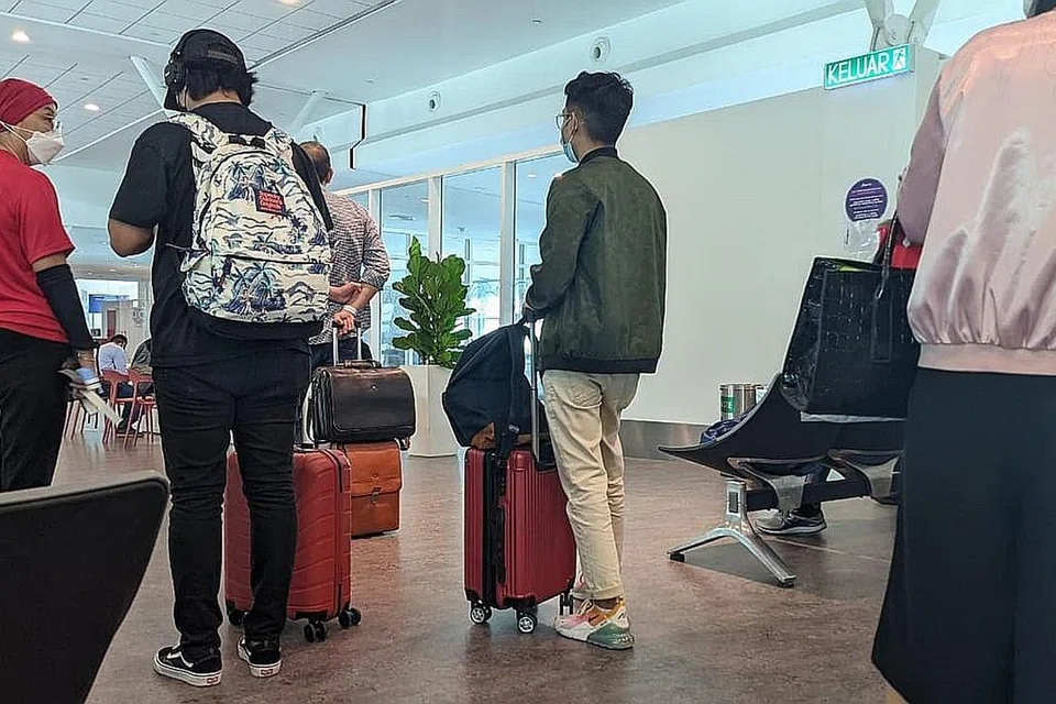 IKUTI PROTOKOL: Penumpang yang tiba di KLIA pagi semalam beratur untuk melakukan ujian PCR (gambar atas). Setiap penumpang diwajibkan memakai gegelang biru sebagai penandaan jalani ujian PCR. - Foto-Foto AHMAD SAMION ISMAIa