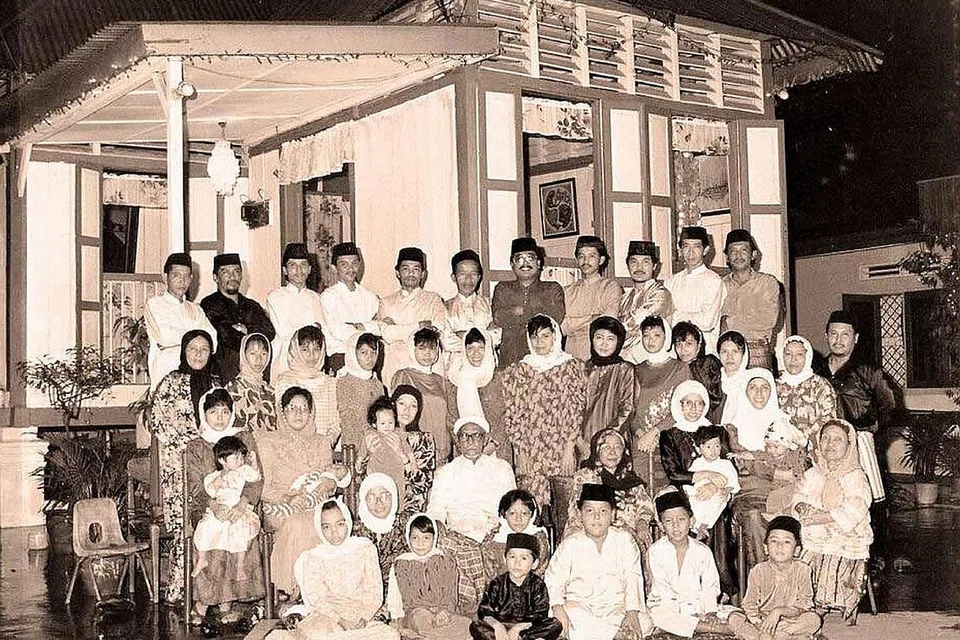 MEMORI: Keluarga besar Haji M Amin Haji Alias bergambar di depan rumah pusaka pada 1980-an. - Foto FACEBOOK KAMPUNG TEMPE