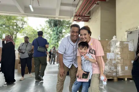 INGIN BERBAKTI: Cik Nurul Hamzah, 36 tahun; tunangnya Encik Ariandy Majid, 48 tahun dan anaknya Aryan Ibraheem, enam tahun antara 100 relawan yang hadir pada acara pembungkusan barang keperluan bagi mangsa di Gaza anjuran pertubuhan tidak meraih untung, Humanity Matters pada pagi Ahad.