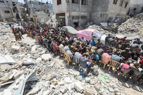 Penduduk Palestin makan bersama juadah yang dimasak oleh sebuah badan amal di tapak bangunan yang musnah akibat serangan Israel di Khan Younis, Gaza, pada 30 Mei. Serangan Israel ke atas Rafah menghentikan aliran bantuan Pertubuhan Bangsa-Bangsa Bersatu (PBB) ke wilayah Palestin itu.