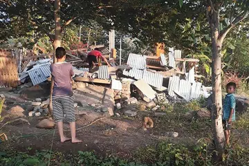 GEMPA BUMI: Penduduk melihat sebuah rumah yang runtuh akibat gempa bumi di Lombok pada 29 Julai 2018.