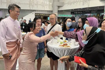 BERAYA BERSAMA: Cik Mariam dan suami (kededua kiri) beramah mesra dengan penduduk (dari kanan) Cik Ainah, Hajah Maimunah serta keluarga Cik Teo (tiga dari kiri) semasa acara 'rumah terbuka' GRC Sembawang di Kampung Admiralty semalam. - Foto BH oleh ERVINA MOHD JAMIL