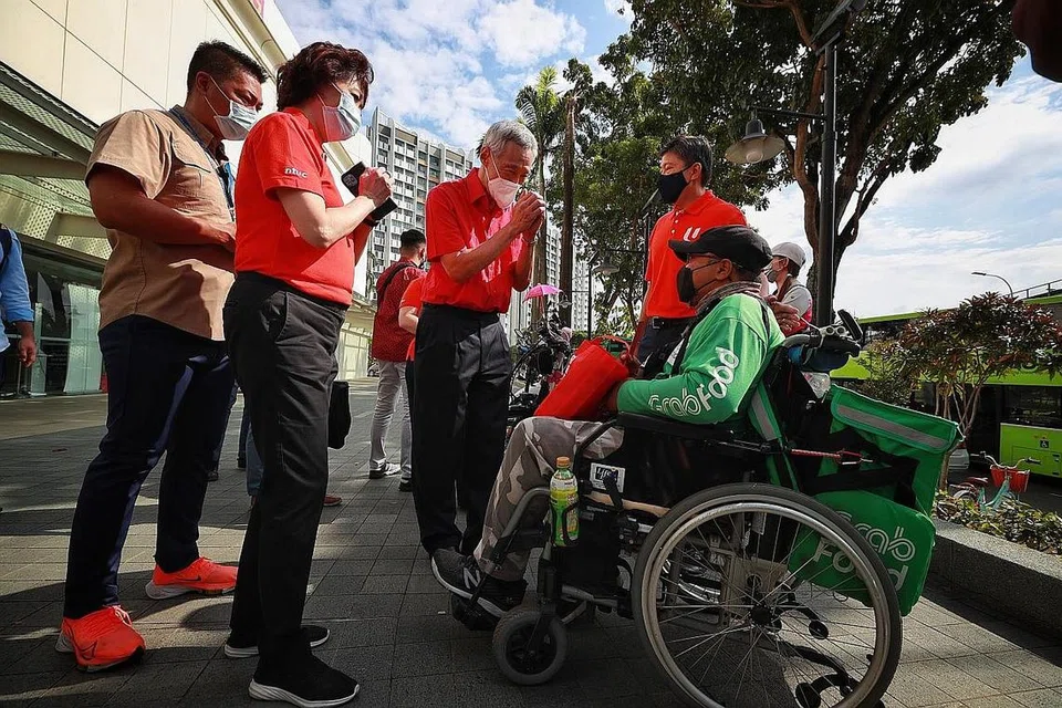 HARGAI PEKERJA: Encik Lee (tiga dari kiri), menemui pekerja penghantaran seperti Encik Suhaimi Suboh (kanan) di Jurong Point semalam untuk mengucapkan Selamat Tahun Baru Cina dan menghargai kerja keras mereka. Turut bersama Presiden NTUC, Cik Mary Liew, (dua dari kiri) dan Setiausaha Agung NTUC, Encik Ng Chee Meng (di kiri Encik Lee). - Foto BH oleh JASON QUAH