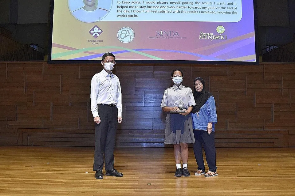MENCAPAI KECEMERLANGAN: Amira Akhtar (tengah), yang kini menuntut di Maktab Rendah Kebangsaan di bawah Program Bersepadu (IP) telah meraih anugerah Pelajar Keseluruhan Terbaik (Kategori PSLE). - Foto SELF-HELP GROUPS SINGAPORE