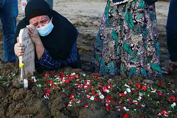 RATAPI PEMERGIAN: Seorang wanita menangisi pemergian mangsa jangkitan Covid-19, Allahyarham Abdul Rochman, 36 tahun, selepas jenazahnya dikebumikan di tanah perkuburan yang disediakan pemerintah untuk mangsa koronavirus pada 12 Julai lalu, sedang kes terus meningkat di Jakarta. - Foto REUTERS