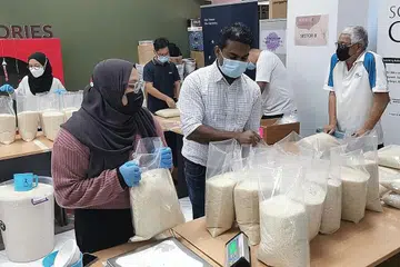 TANPA MENGIRA BANGSA: Relawan berbilang kaum, agama dan latar belakang berkumpul sempena Hari Keharmonian Kaum untuk membungkus beras bagi golongan yang memerlukan sebagai sebahagian daripada projek Movement R Humanity Matters.- Foto HUMANITY MATTERS