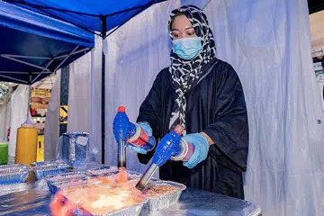 BAKAR SUSHI: Cik Siti Raudah Osman membakar dulang sushi di gerainya di Bazar Kampong Glam untuk dijual kepada pelanggan. - Foto BH oleh NUR DIYANA TAHA