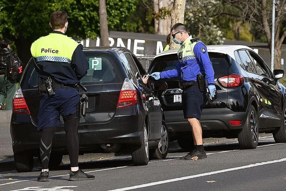 TIADA PILIHAN KECUALI SEKATAN KETAT: Pegawai polis menahan sebuah kereta bagi pemeriksaan lesen dan permit di Melbourne semalam, semasa satu sekatan tahap empat ketat di ibu kota Victoria itu disebabkan pandemik Covid-19. Negeri Victoria melaporkan 19 kematian akibat Covid-19 semalam, walaupun jumlah kes baru berkurangan. - Foto AFP