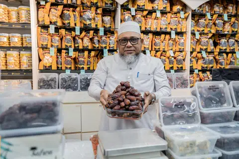 Pengasas dan pengerusi Al Barakah Beauty and Health Mart, Encik A Rahman Bahurudeen bersama pelbagai jenis kurma yang dijual di kedainya di Joo Chiat Road.
